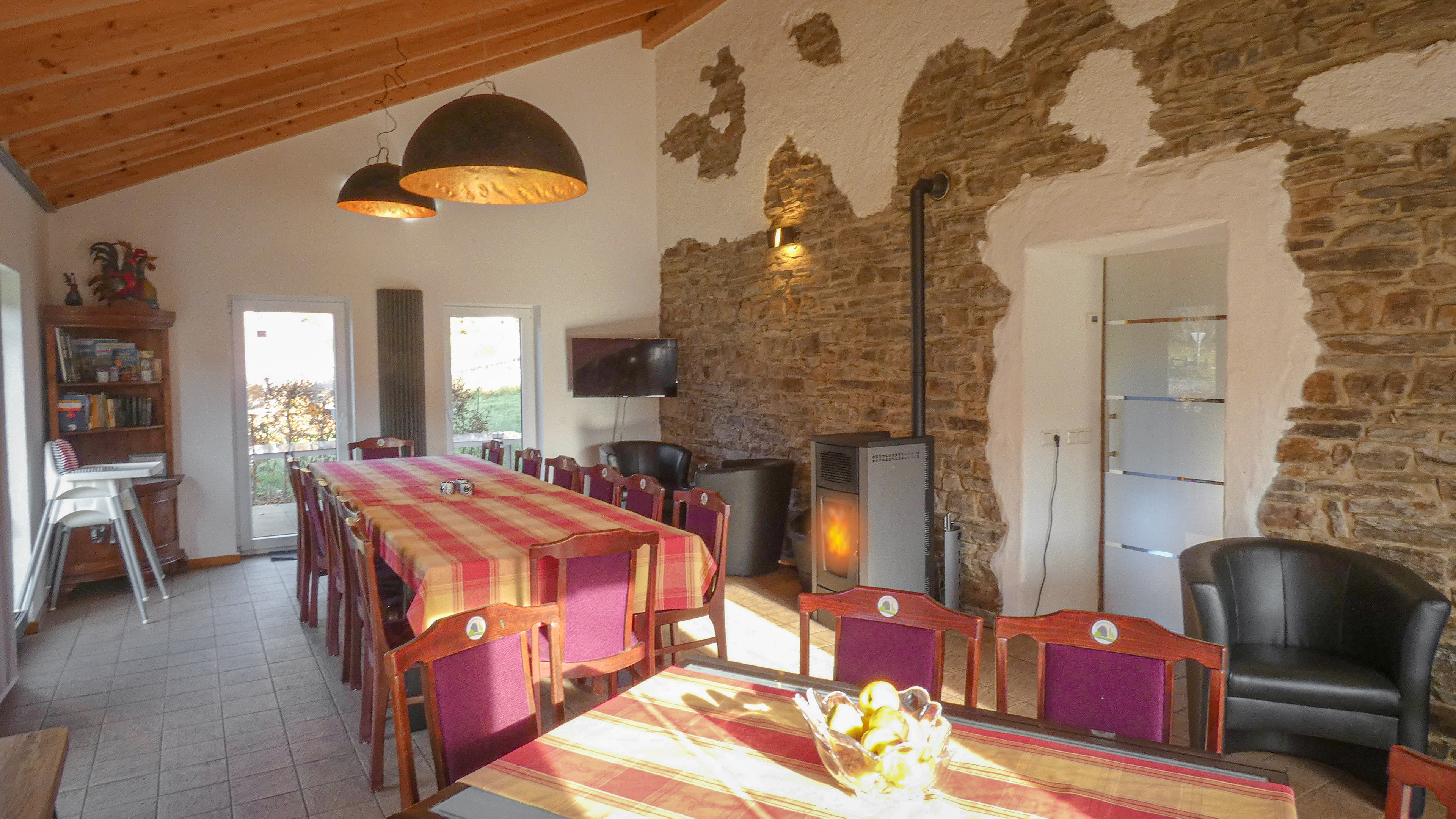 Ferienhaus Eifel Landhaus mit markanter, mächtigen Bruchsteinwand im Esszimmer 